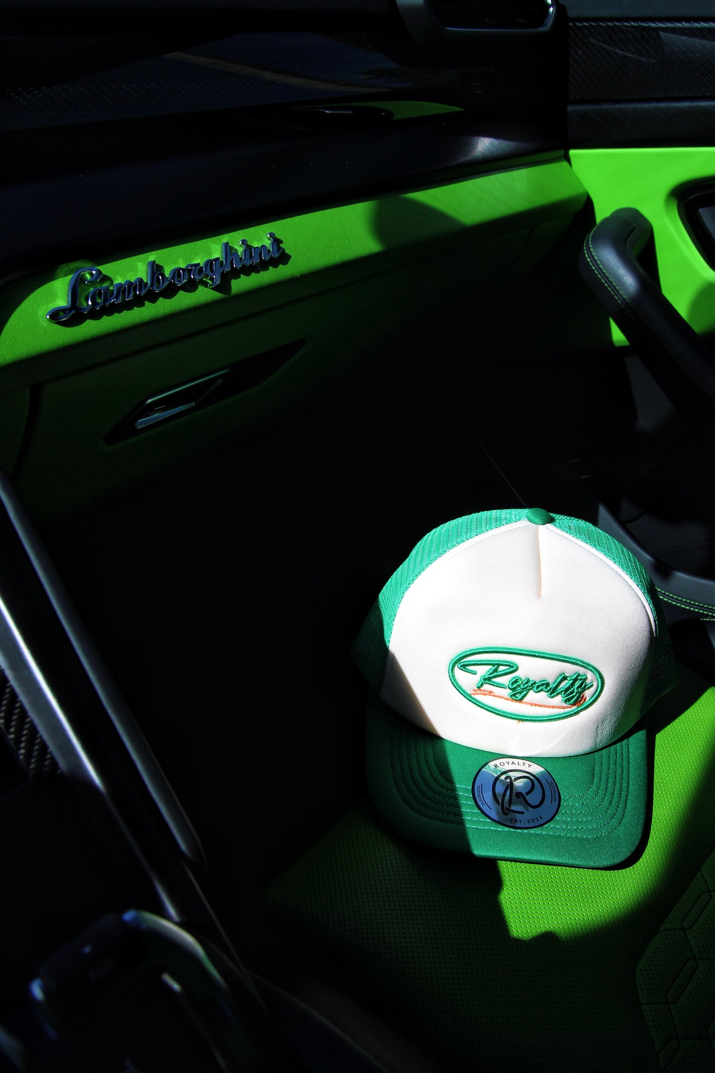 Cap with a logo on a car dashboard with 'Lamborghini' branding.