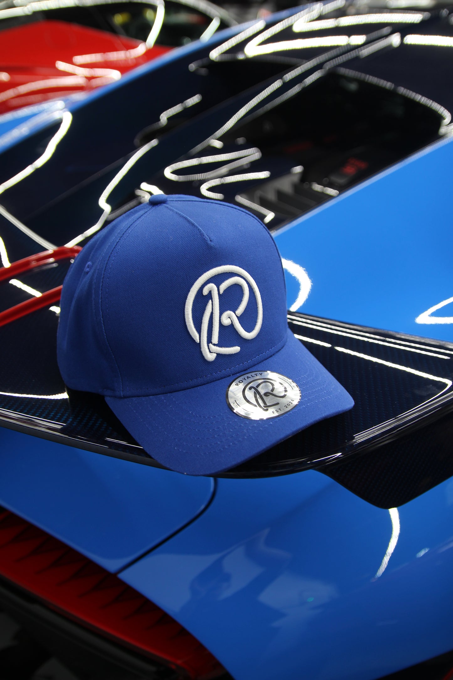 Blue cap with a logo on a blue car with neon lights in the background
