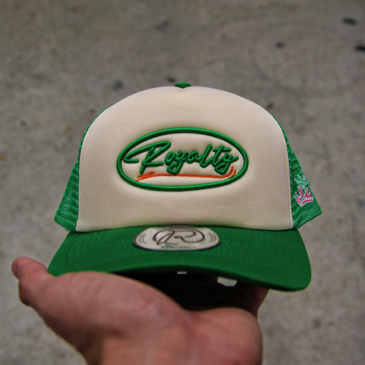 Green and white cap with 'Royalty' logo held by a hand on a concrete surface