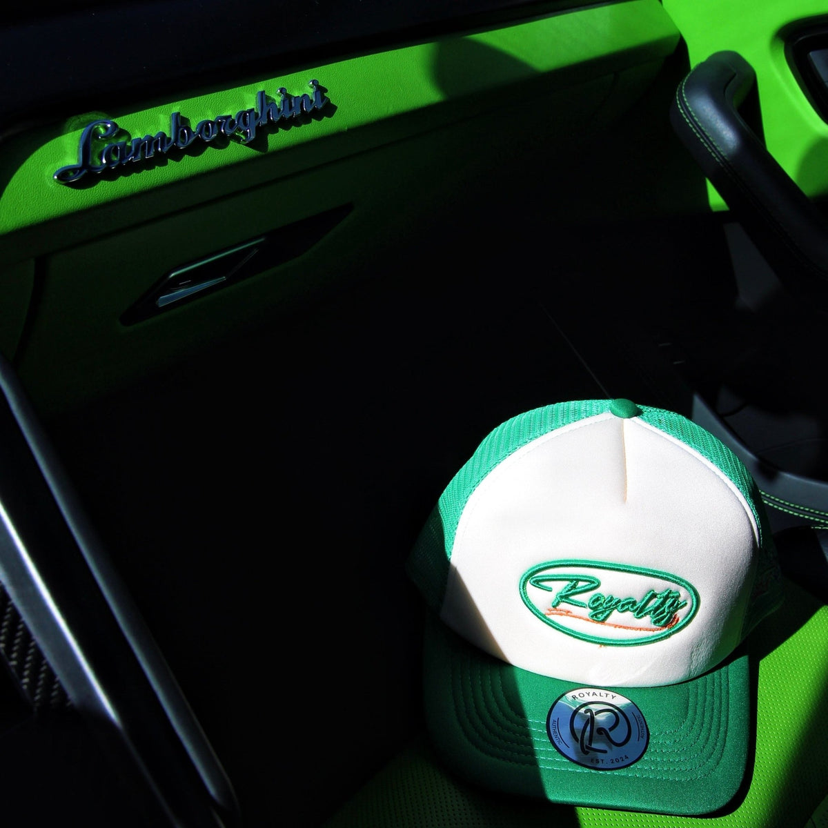 Cap with a logo on a car dashboard with 'Lamborghini' branding.