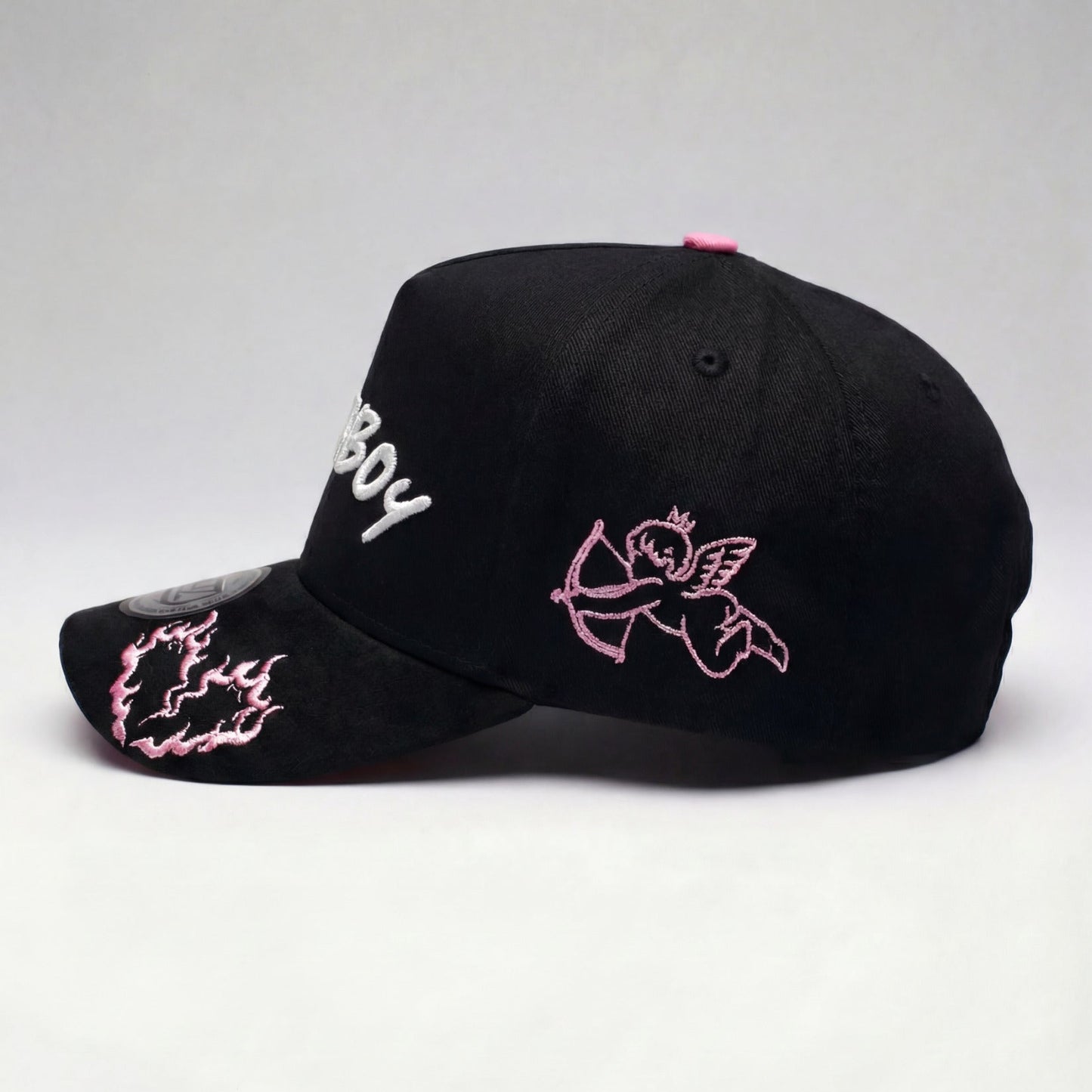 Black cap with pink and white designs on a light gray background